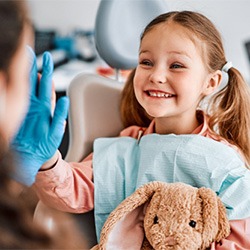 Little girl with stuffed rabbit at dentist 