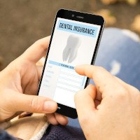 Patient in Midwest City checking their dental insurance for tooth extractions